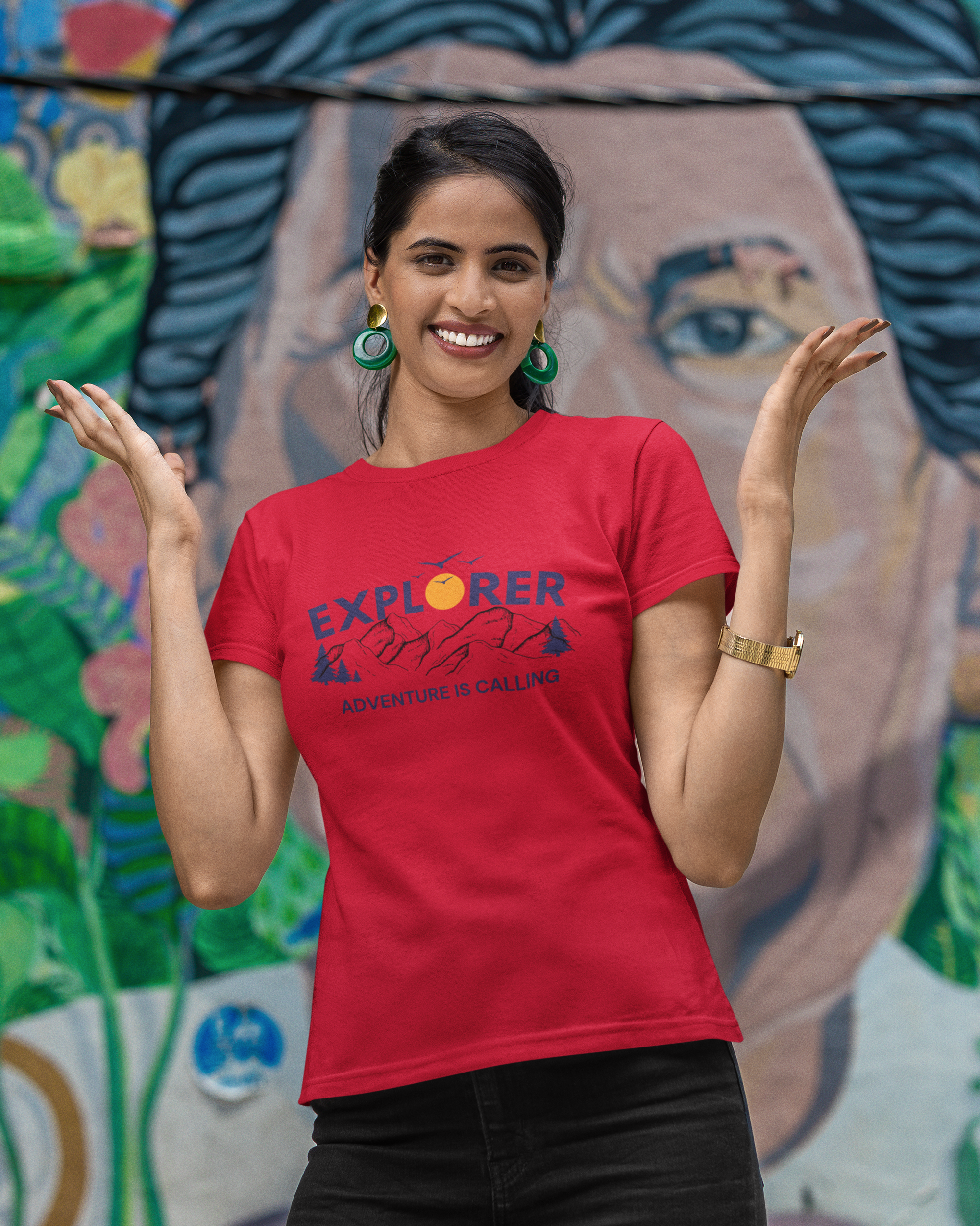 Woman wearing a red t-shirt with 'Explorer' text, standing in front of a colorful mural.