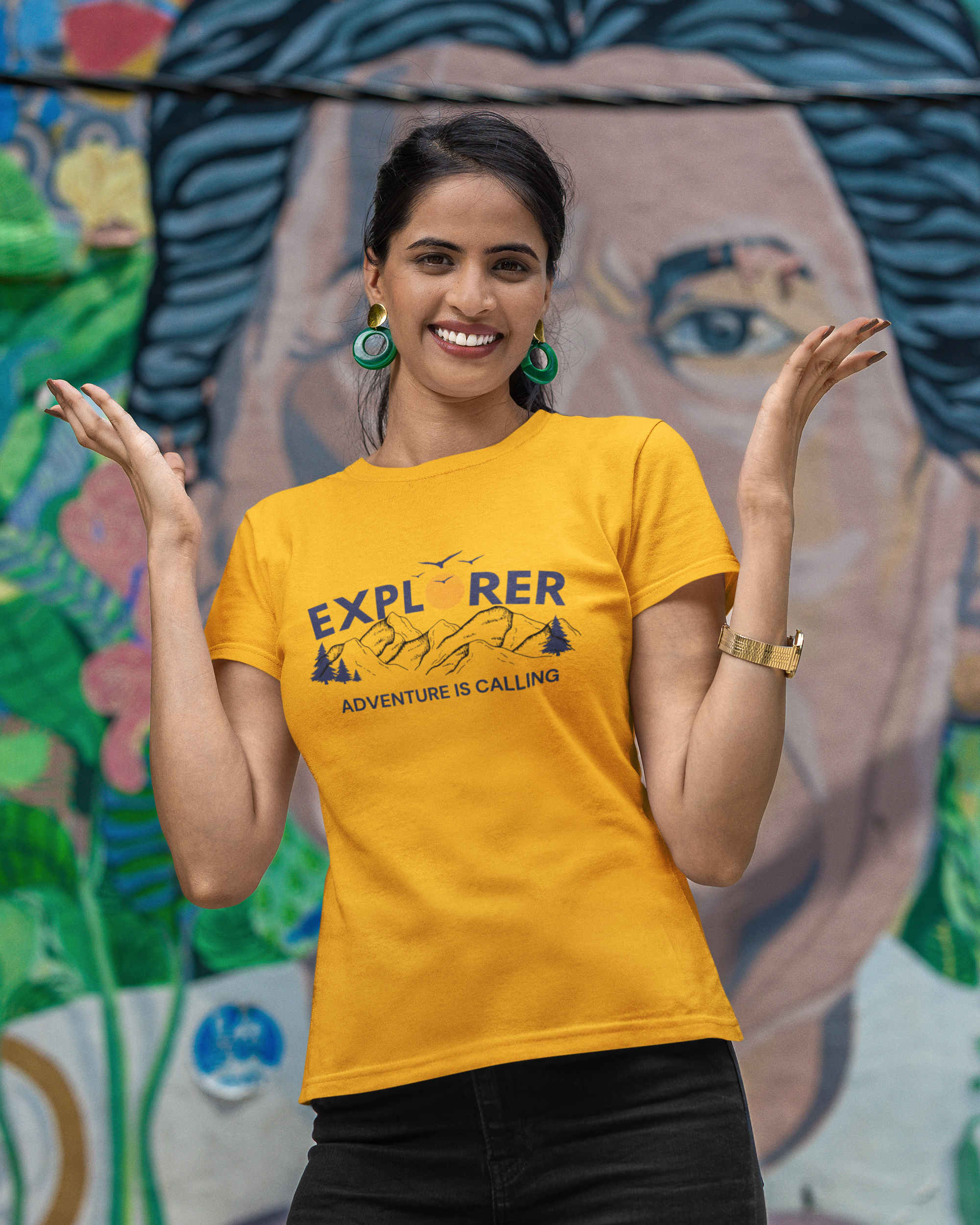 Woman wearing a yellow t-shirt with text in front of a colorful mural