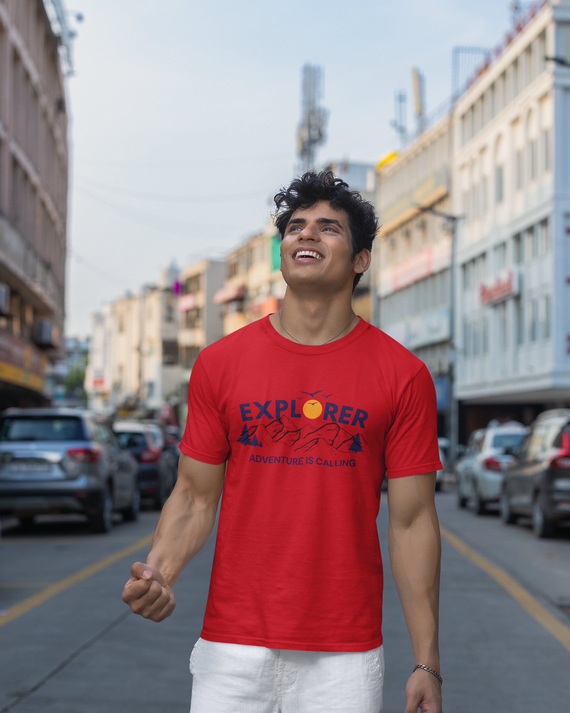 Man wearing a red t-shirt with 'Explorer' text on a city street