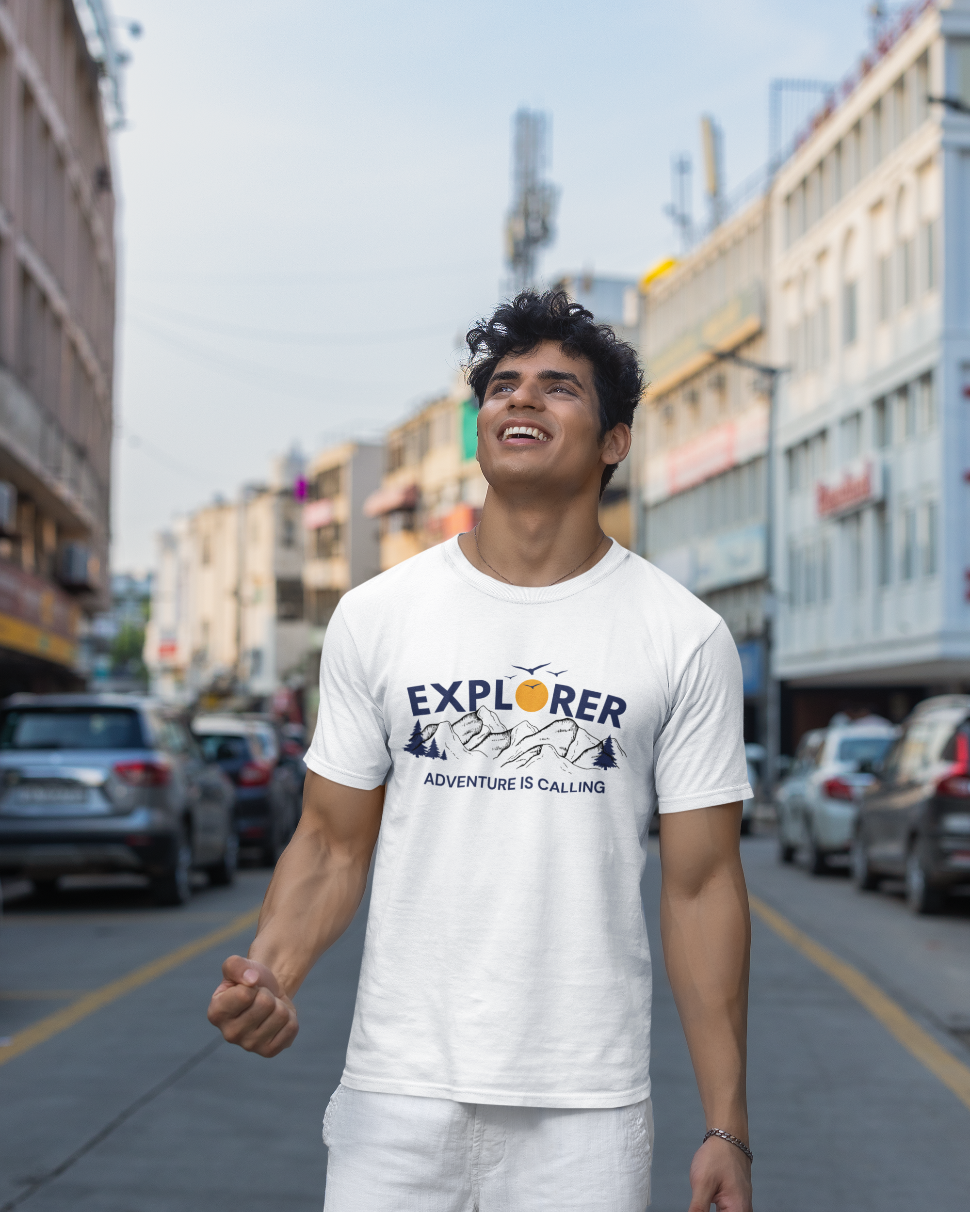Man wearing a white t-shirt with 'Explorer' text on a city street