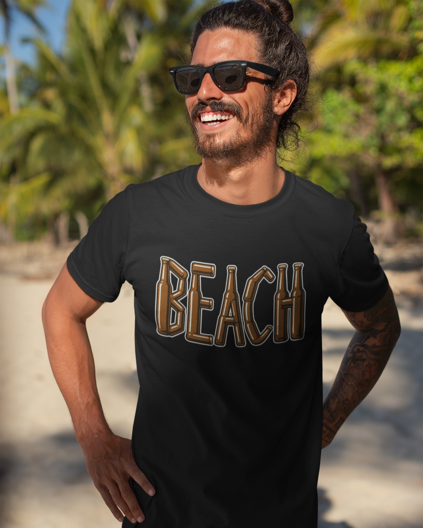 Man wearing a black t-shirt with 'BEACH' printed on it, standing on a beach.