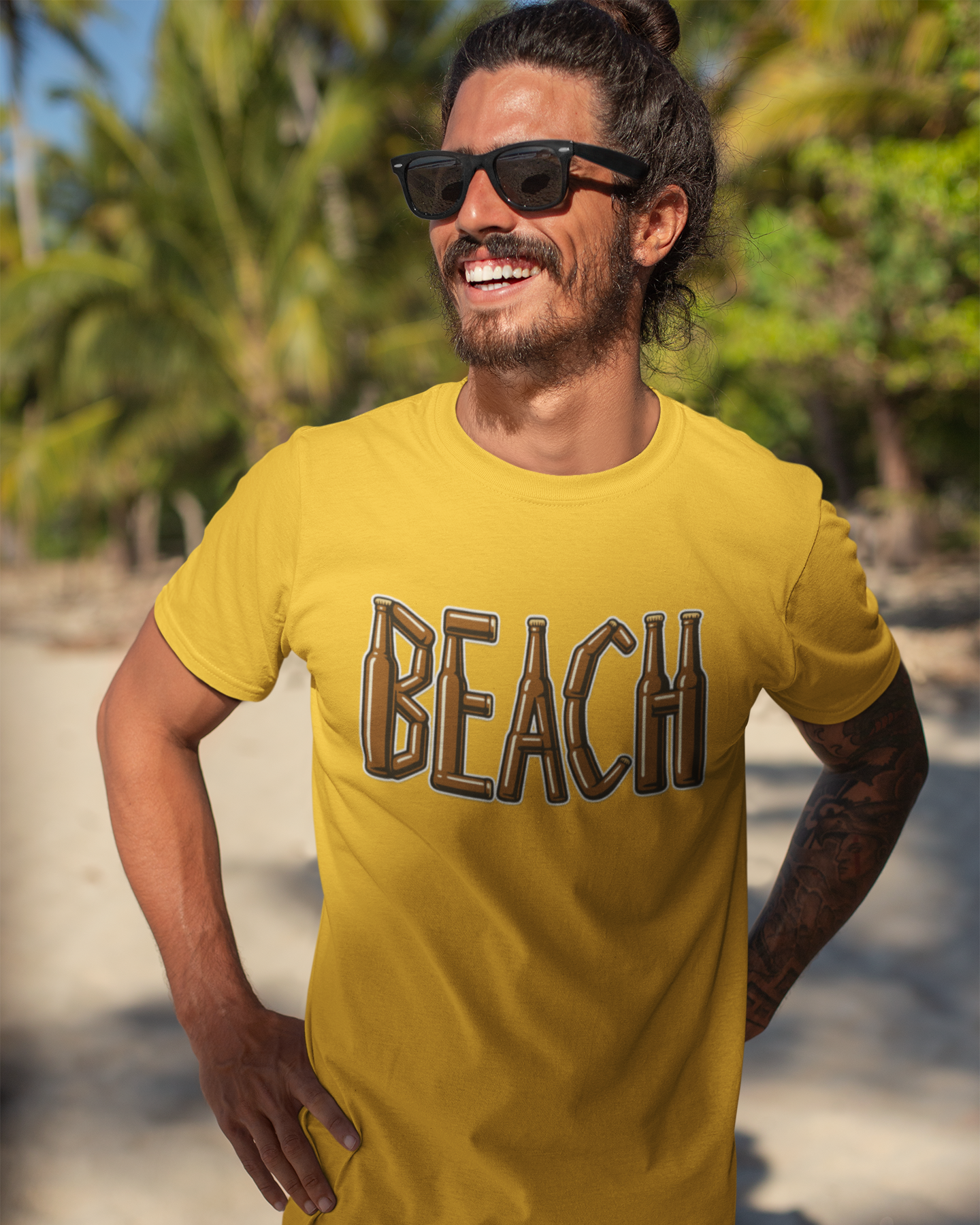 Man wearing a yellow 'BEACH' t-shirt on a beach with palm trees in the background