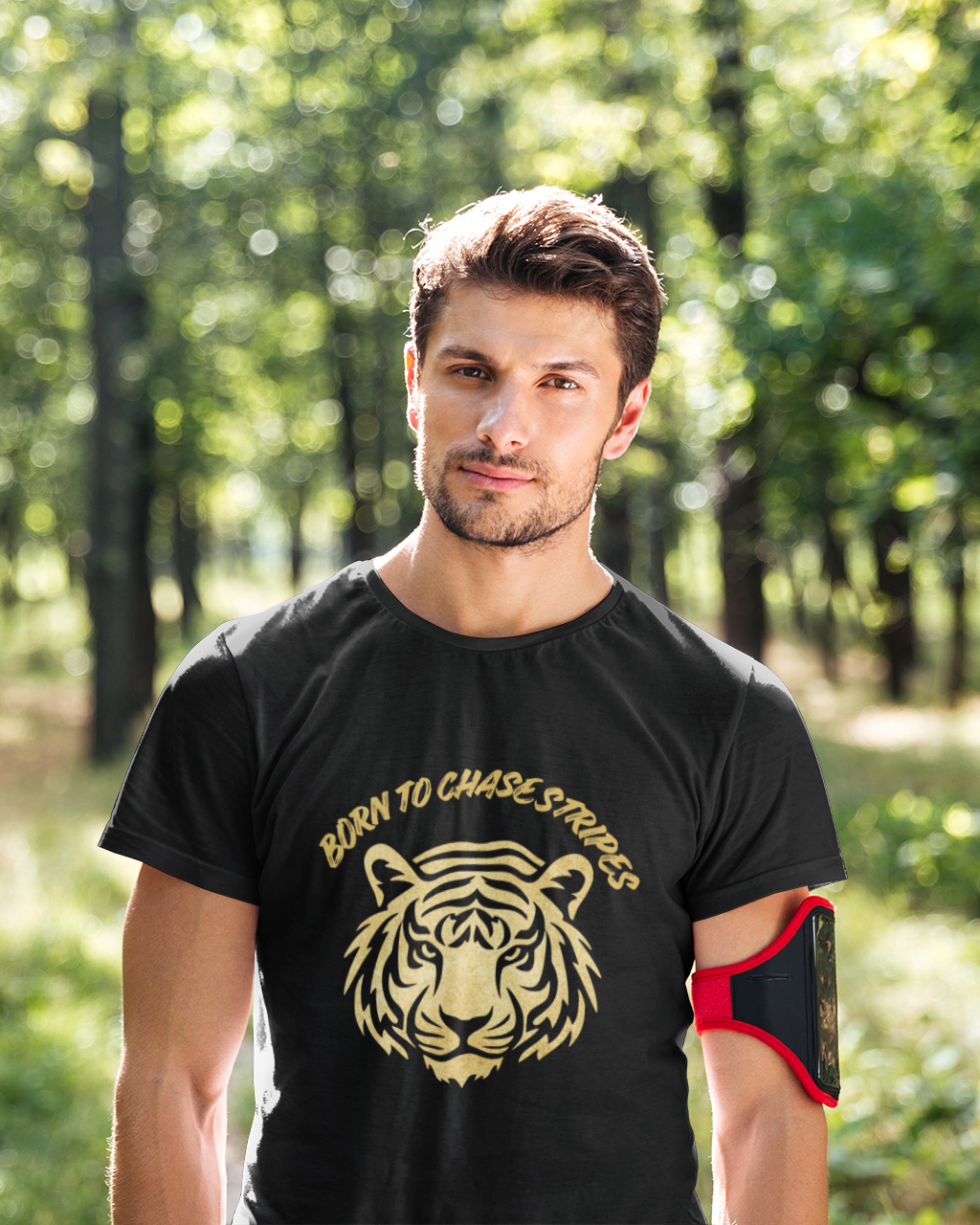 Man wearing a black t-shirt with a tiger logo in a forest setting