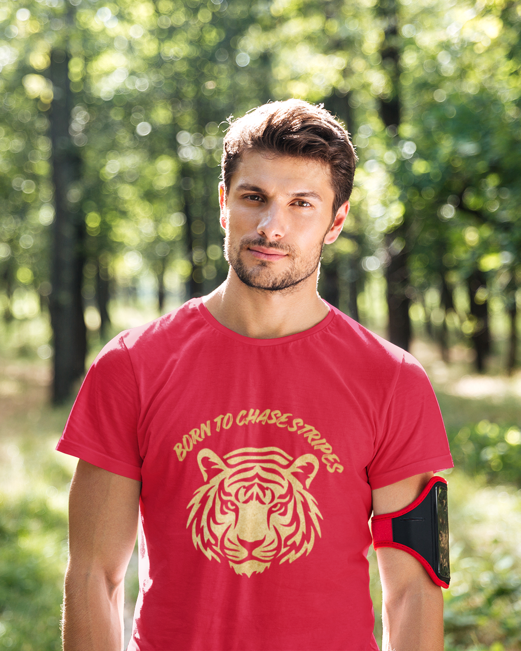 Man wearing a red t-shirt with a tiger logo in a forest setting