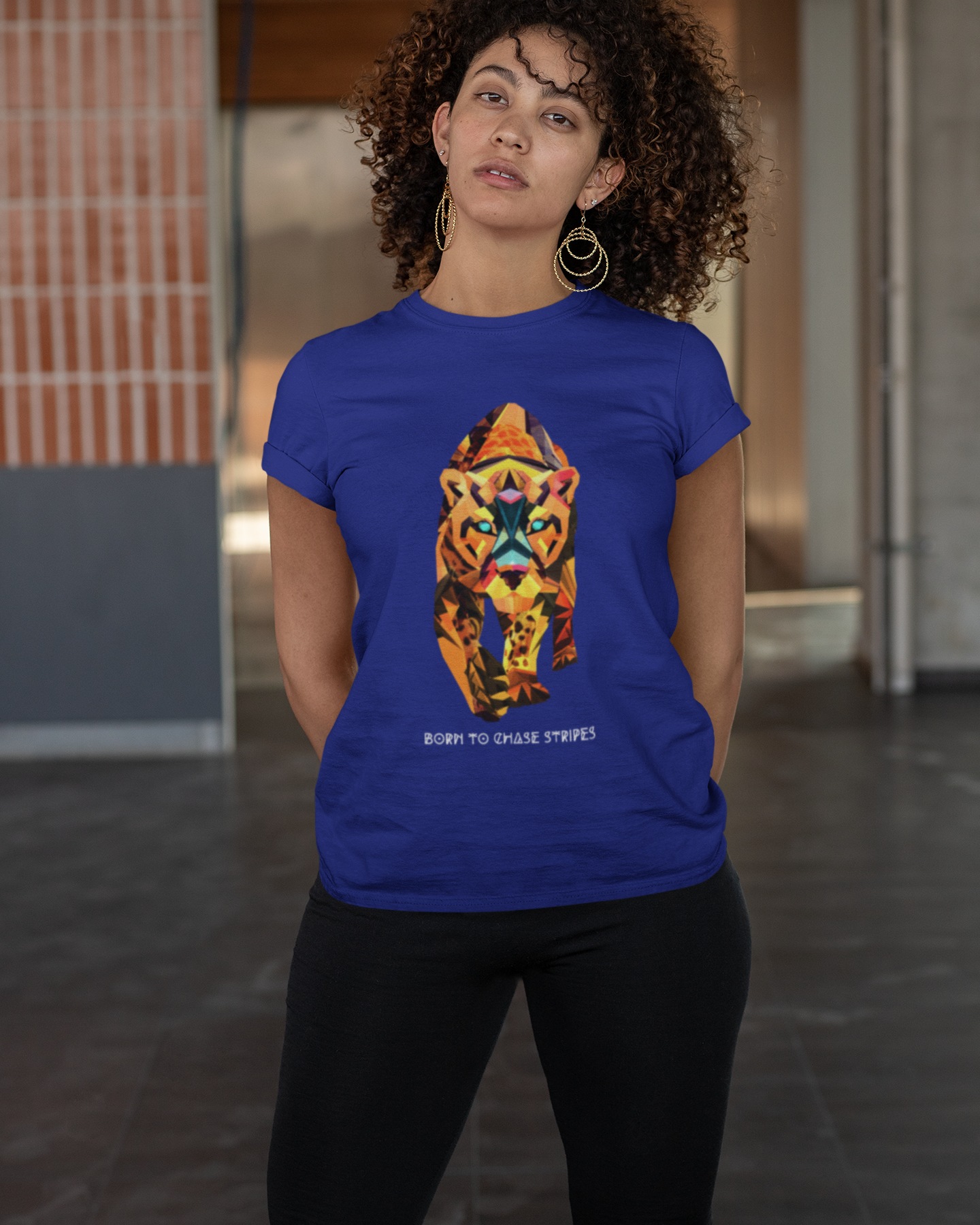 Person wearing a blue t-shirt with a colorful tiger design in an indoor setting
