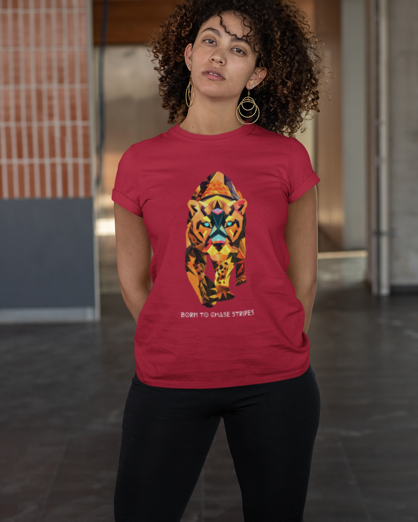 Woman wearing a red t-shirt with a colorful tiger graphic design in an indoor setting.