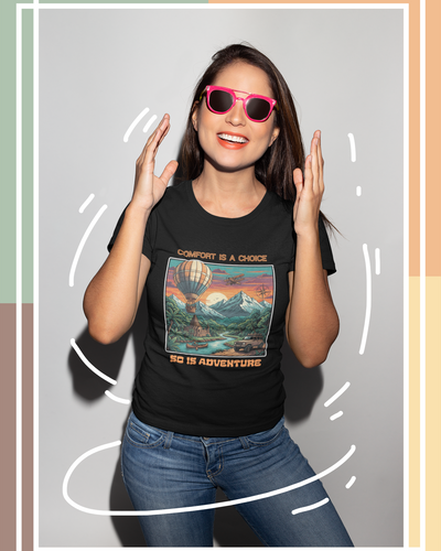 Woman wearing a black t-shirt with a scenic design and sunglasses, standing against a light gray background.