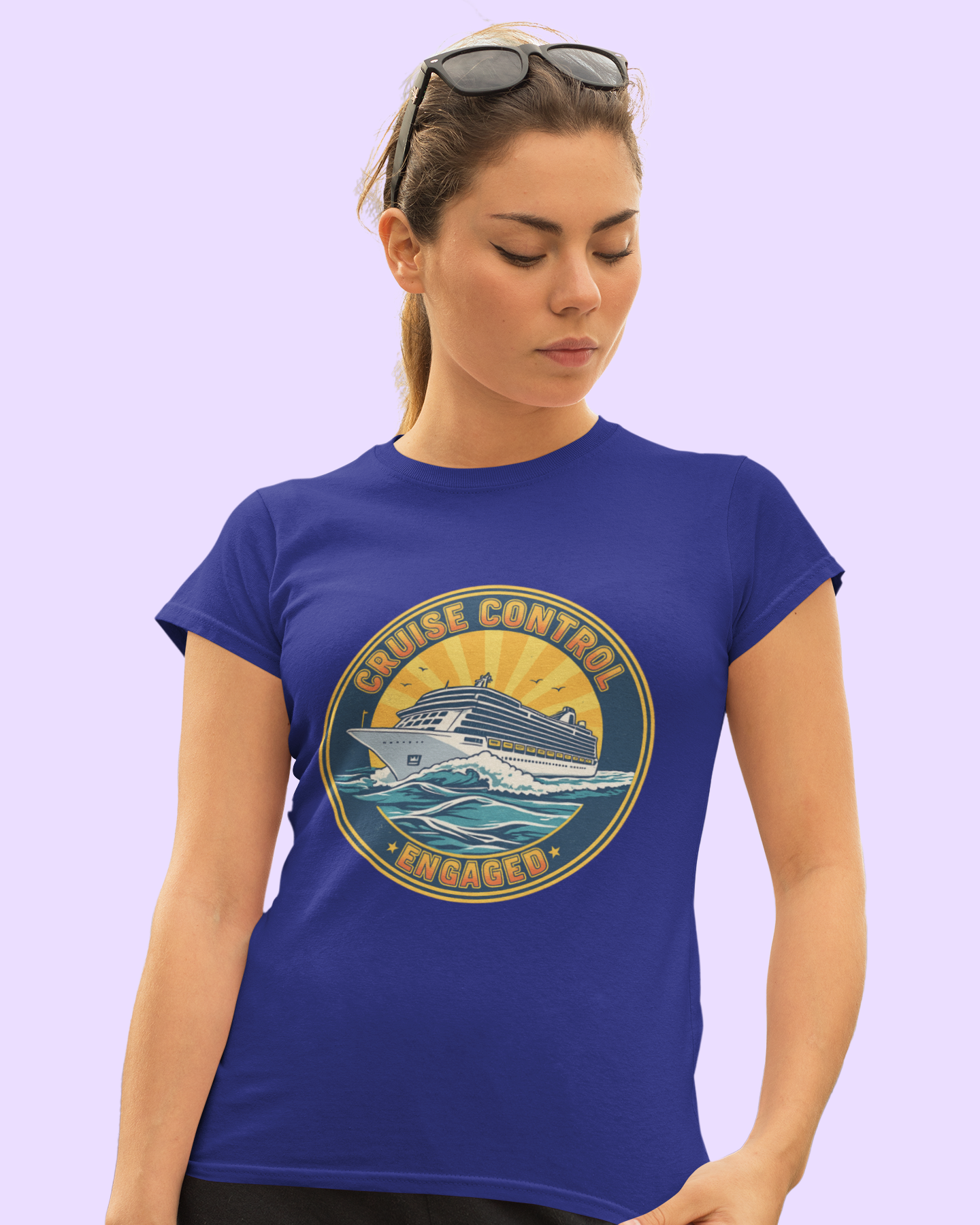 Woman wearing a blue t-shirt with a cruise-themed graphic design on a light purple background