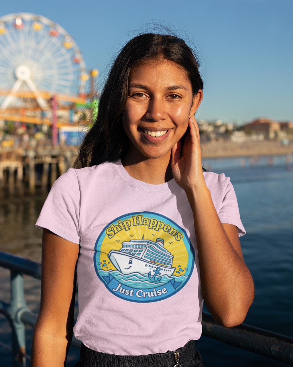 Woman wearing a t-shirt with a logo in front of a Ferris wheel and water.