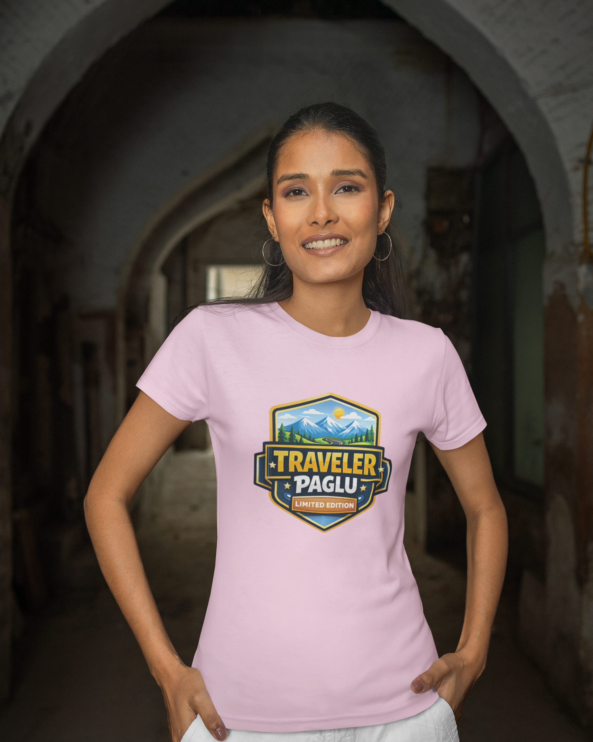 Woman wearing a pink t-shirt with a 'Traveler Paglu' logo in an arched doorway.