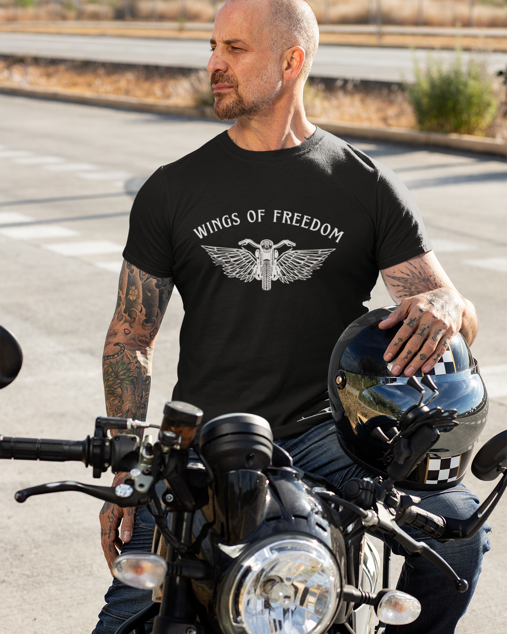 Man wearing a 'Wings of Freedom' t-shirt on a motorcycle.