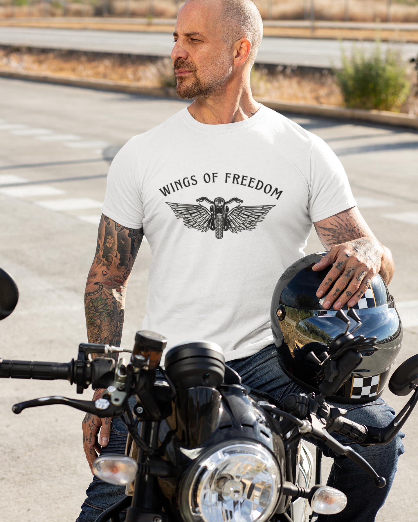 Man wearing a 'Wings of Freedom' t-shirt on a motorcycle.