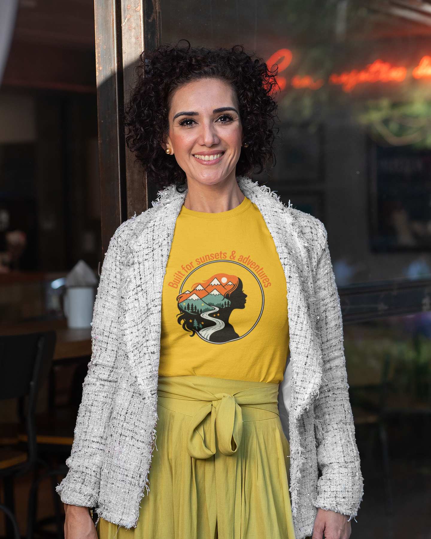 Woman wearing a yellow t-shirt with a graphic design in a casual setting