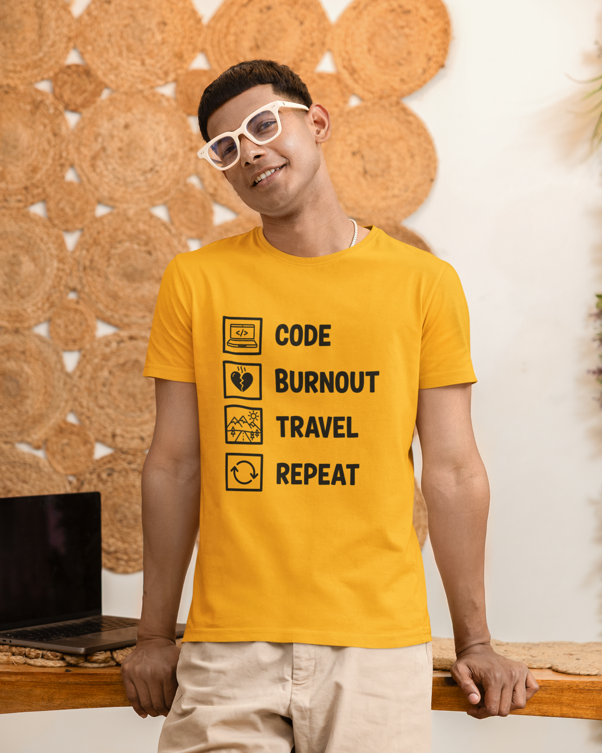 Person wearing a yellow t-shirt with text design, standing against a textured wall.