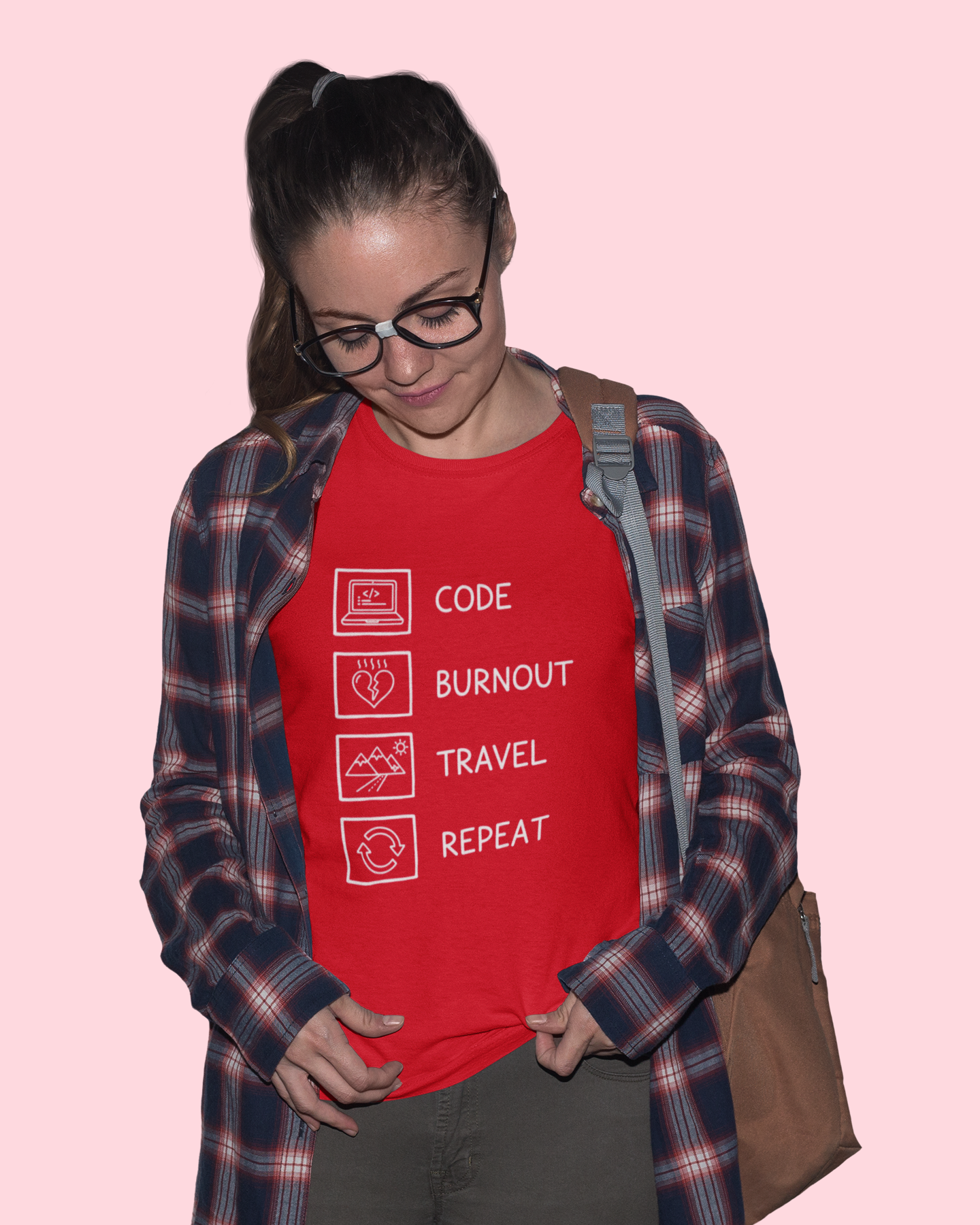 Person wearing a red t-shirt with text and symbols on a pink background