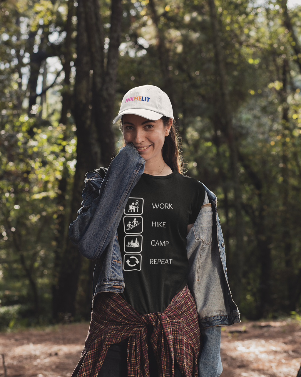 Person wearing a cap and t-shirt with outdoor-themed text in a forest setting
