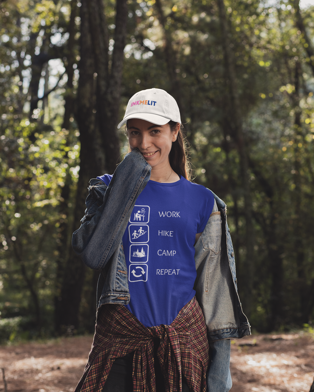 Person wearing a blue t-shirt with outdoor-themed graphics and text, standing in a forest.
