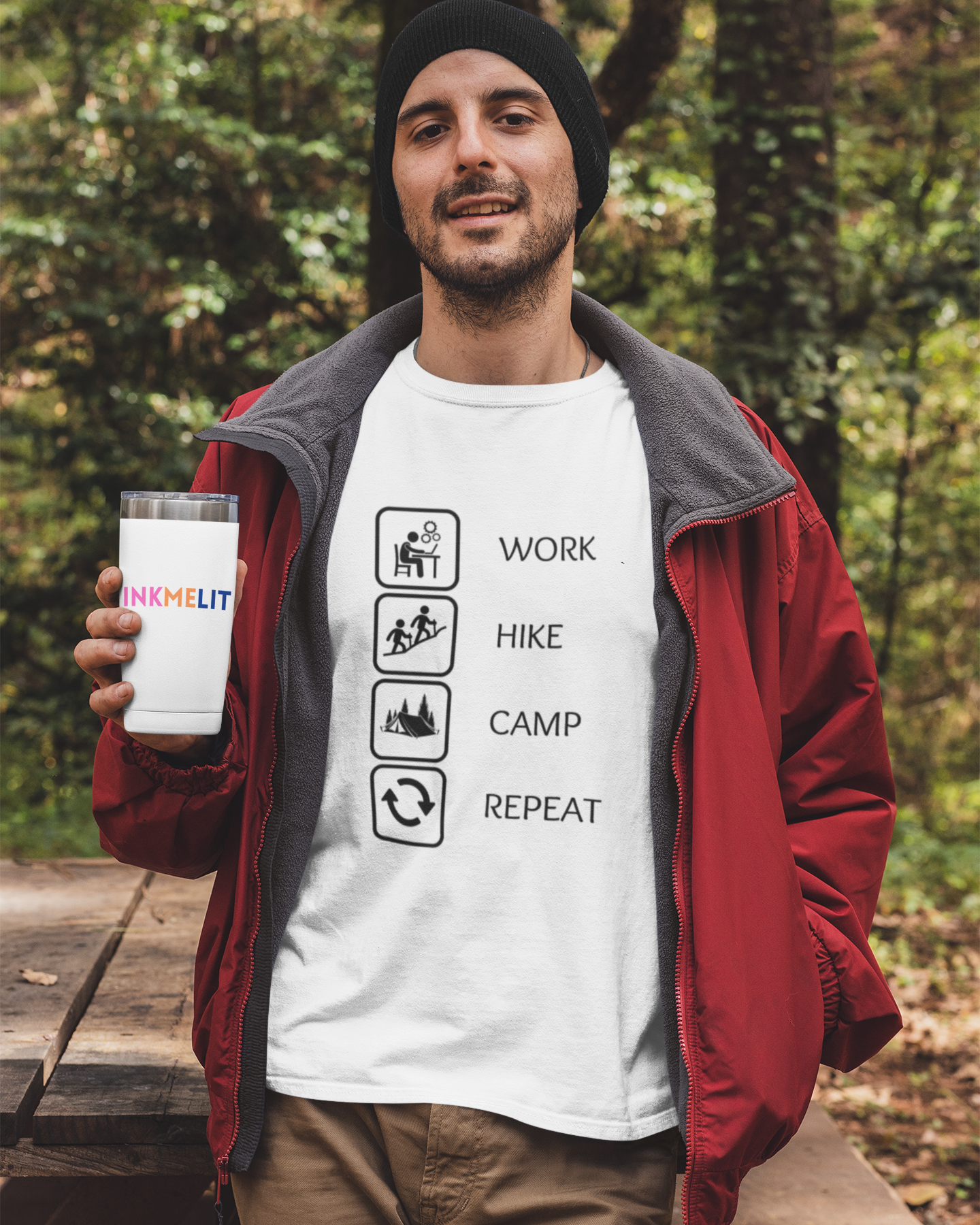 Man holding a mug with a forest background wearing a white t-shirt with outdoor-themed graphics and text.